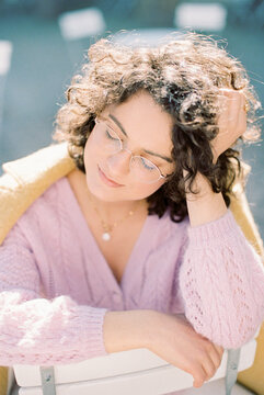 young woman with curly hair in glasses