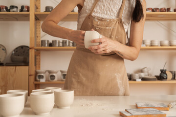 Anonymous Female Artisan Working On A Ceramic Cup