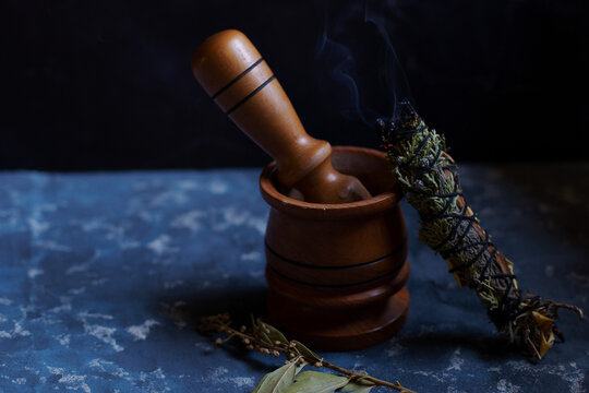 Detail of a wooden mortar kitchen next to a herbal wand stick