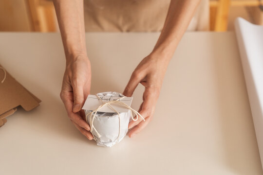 Anonymous Woman Holding An Object Wrapped In The Paper As A Gift