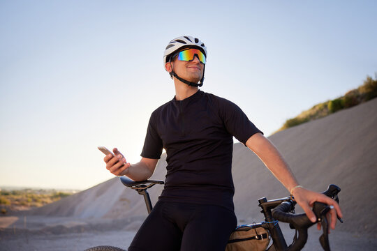 Male cyclist using smartphone on bike