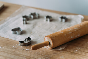 Cookie dough cutters, baking paper and roller pin.