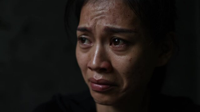 Slow motion, Close-up of a woman crying, tears streaming down her face. Concept to stop violence against women, human trafficking, rape.