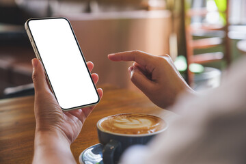 Mockup image of hands holding and touching on mobile phone with blank desktop screen with coffee...