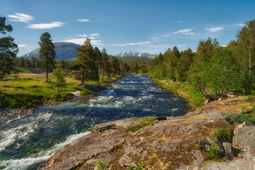 Fototapeta na wymiar A view of a river surrounded by mountains in central Norway, around Romsdalen