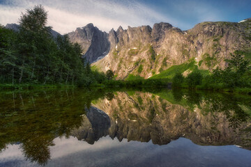 View of the beautiful reflection of the mountain called Troll Wall surrounded by mountains, in central Norway, near the famous Troll Ladder road