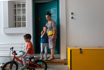 Family is standing In front of their home door, posing for the photo