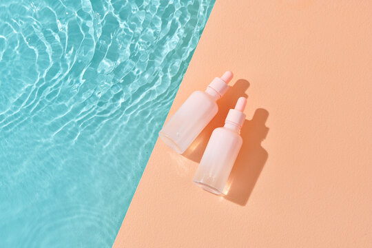 Two bottles of hyaluronic acid lies near swimming pool