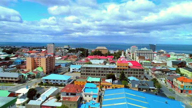 Aerial Forward Beautiful Shot Of Residential City By Sea, Drone Flying Forward Over Roofs On Sunny Day - Punta Arenas, Chile