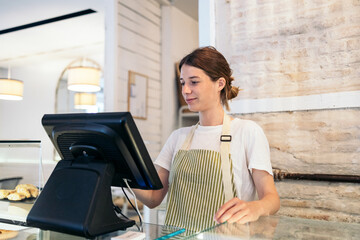 Clerk using POS terminal in a coffee shop