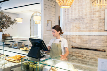 Clerk using POS terminal in a coffee shop