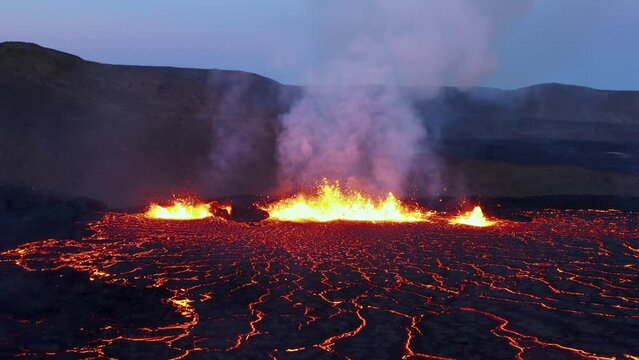 Iceland fissure volcano eruption at night with molten magma spewing, hell like landscape