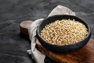 Raw green buckwheat on dark background. Food ingredients.