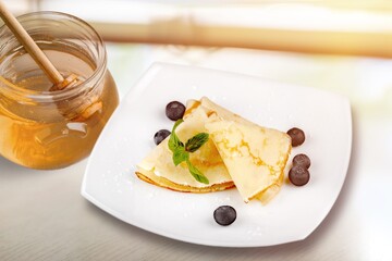 Tasty sweet pancakes, fresh blueberry, honey bowl. Tasty homemade breakfast.