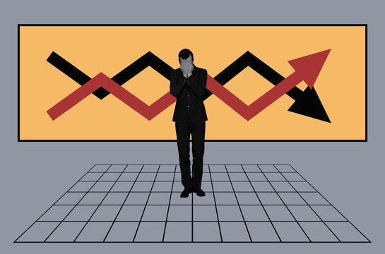 A man covers his face with his hands against Charts on background