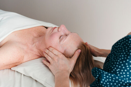 Elderly woman having face massage at spa.