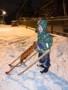 One kid with sleds outdoors on the snow