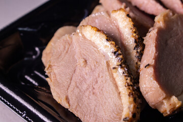 Takeout smoked duck breast slices in the food tray. Closeup image.