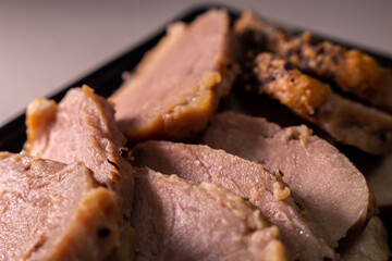 Takeout smoked duck breast slices in the food tray. Closeup image.