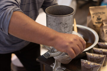 Manos de hombre trabajando con un molino de mano. (moler cafe). Concepto de tradiciones.
