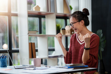 Asian business women are delighted and happy with their work and success on their laptop at home.