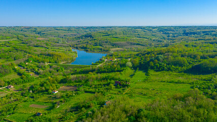 Aerial view over woodland near water, lake
