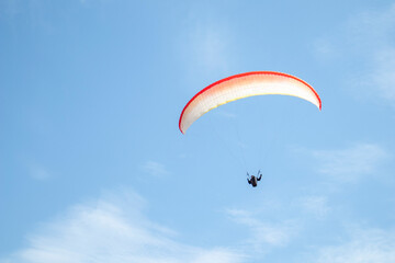 paragliding. extreme sport. a guy on a paraglider flies in the blue sky