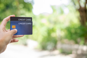 Credit Card. hand holding credit card with green nature background and copy space concept online shopping and Payments