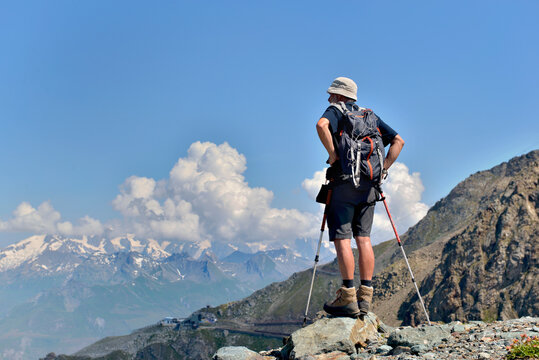 hiker standing and watching the landscape at the top of mountains in European Alps
