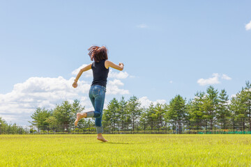 Fototapeta premium 素足で芝生を走り回る女性