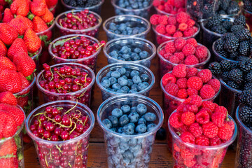 Fresh juicy berries on farmer market, Colorful different fruit sets at street cafe