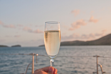 Bubby sparkling champagne flute glass with evening scene while sailing in the Pacific Ocean in Queensland Australia