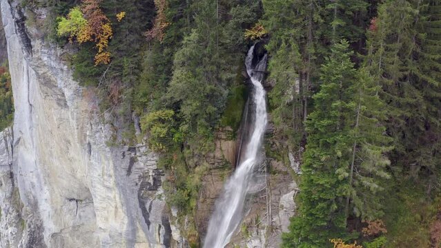 Aerial view of a waterfall surrounded by autumn colors in Lauterbrunnen, Switzerland