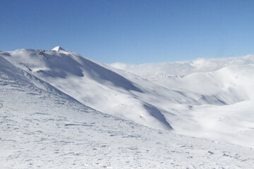 Fototapeta na wymiar The winter landscape of snow covered Tochal mountains. It is a ski resort located on the Alborz mountain range, adjacent to the metropolitan area of Tehran, Iran.