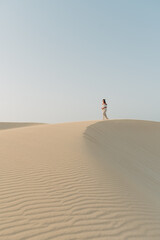 Junge Frau laufend auf Sand Dünen Wüste in Corralejo auf der kanarischen Insel Fuerteventura