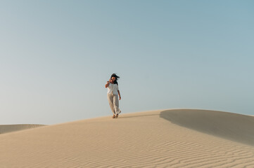 junge Frau läuft über die Sand Dünen von Corralejo auf der kanarischen Insel Fuerteventura in Spanien