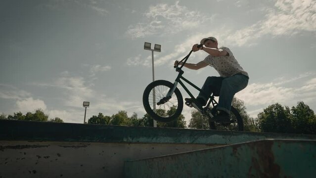Urban youth extreme culture. Bicycle stunts in the city skate park