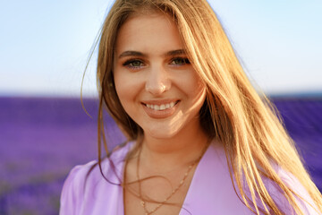 Portrait of a young attractive woman in a lavender field at sunset