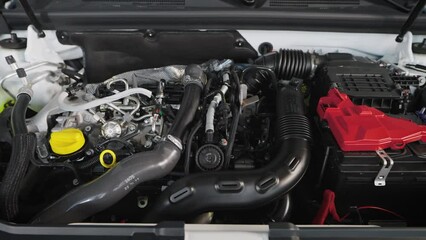 Car engine under the hood of a modern car. New car in the showroom.
