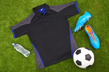 Flatlay of sportswear or trendy soccer clothes, accessories and equipment on grass background....