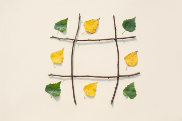 Creative autumn frame. Branches of trees with green and yellow leaves with copy space. Top view, Flat lay