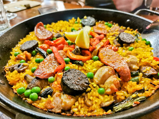 Home made Spanish Paella with black chorizo sausages  served in black pan