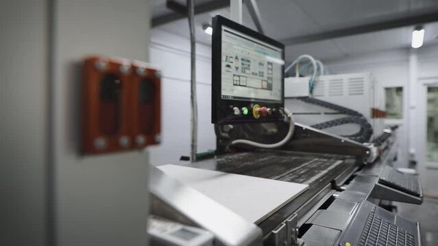 An industrial printer in a porcelain tile factory. The printer applies a pattern and texture to the board blank.