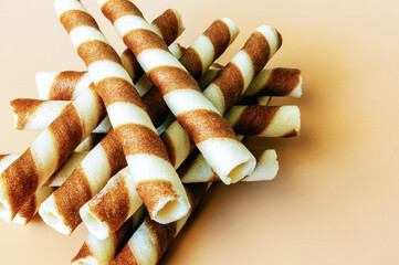 waffle striped tubes with cinnamon on orange background, top view