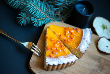 Slices of sea buckthorn pie on festively decorated table. Sugar, gluten and lactose free and vegan.