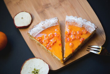 Slices of sea buckthorn pie on festively decorated table. Sugar, gluten and lactose free and vegan.