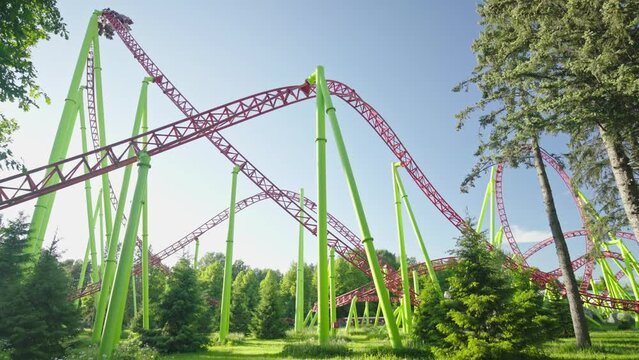 Roller coaster Ride against blue sky. Roller coaster in the amusement park. Cheerful entertainments in park of attractions