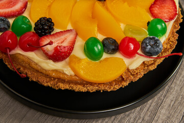 fruitcake with strawberries, blueberries, cherries and peaches close-up view