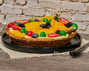 fruit cake with strawberries, blueberries, cherries and peaches side view