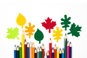 School banner with school supplies crayons and decorative autumn leaves. Back to school concept. Colored pencils isolated on white background. Copy space